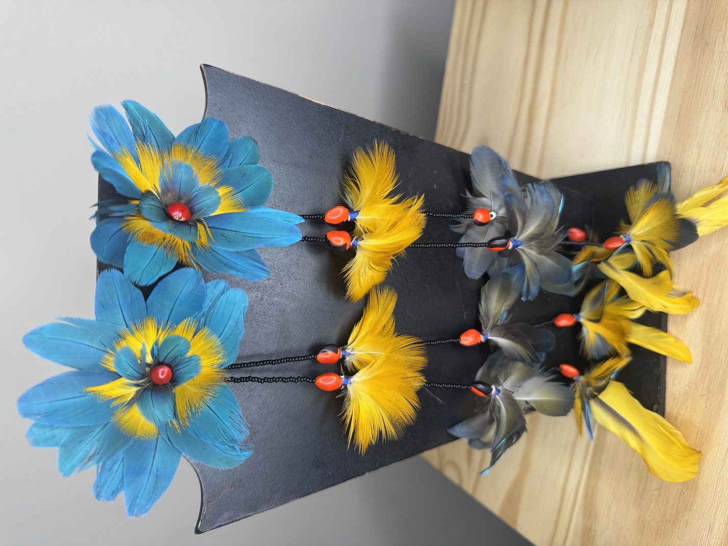 BRINCO XERENTE AZUL/AMARELO DE PENAS